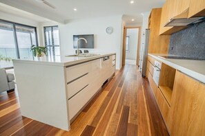 Una cocina moderna con suelo de madera, una isla central y vistas al exterior.
