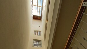 Un intérieur aux plafonds hauts, doté de nombreuses fenêtres et d’un escalier.