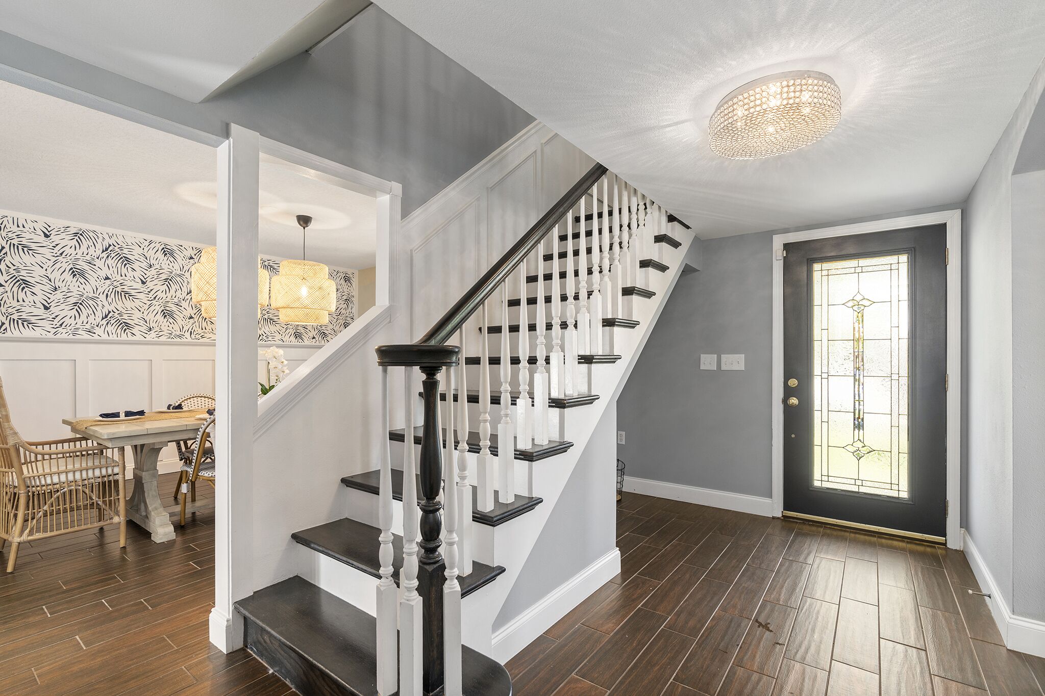 Un escalier avec des balustrades blanches et des marches sombres menant à un palier.