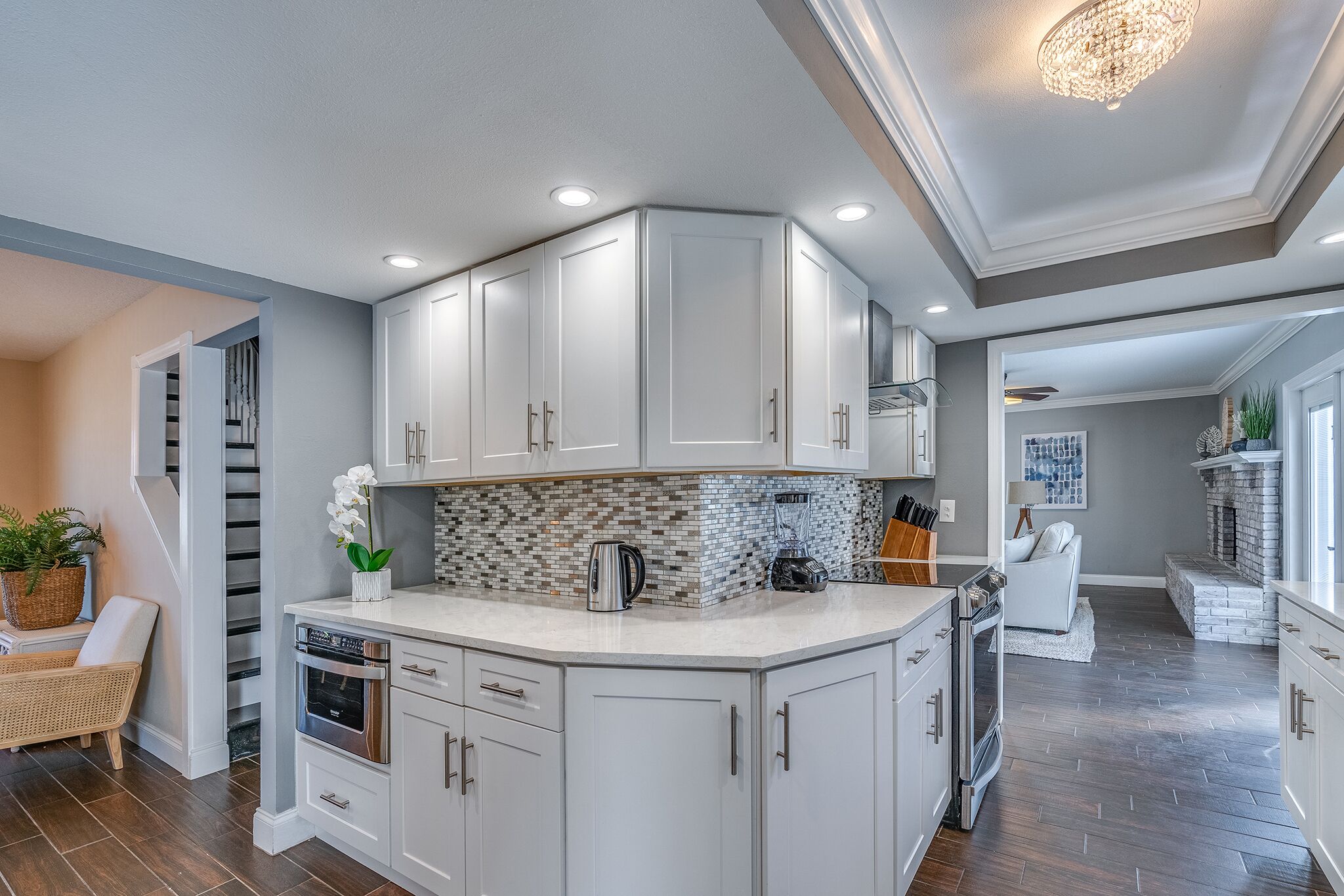 A modern kitchen with white cabinetry, a central island, and a backsplash.
