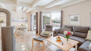 A cozy living room with a sofa, a dining table, and a fireplace. - Awesome home in Krems II/Warderbrück with sauna (Krems II/Warderbrück)