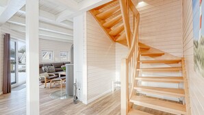 A spacious living area with a wooden staircase, a sofa set, and a large window. - Awesome home in Krems II/Warderbrück with sauna (Krems II/Warderbrück)