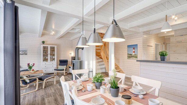 A modern dining area with a wooden table set for a meal, a cabinet with glass doors, and a staircase leading to an upper level. - Awesome home in Krems II/Warderbrück with sauna (Krems II/Warderbrück)