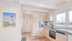 A modern kitchen with wooden cabinets, a microwave, a coffee maker, and a large window. - Awesome home in Krems II/Warderbrück with sauna (Krems II/Warderbrück)
