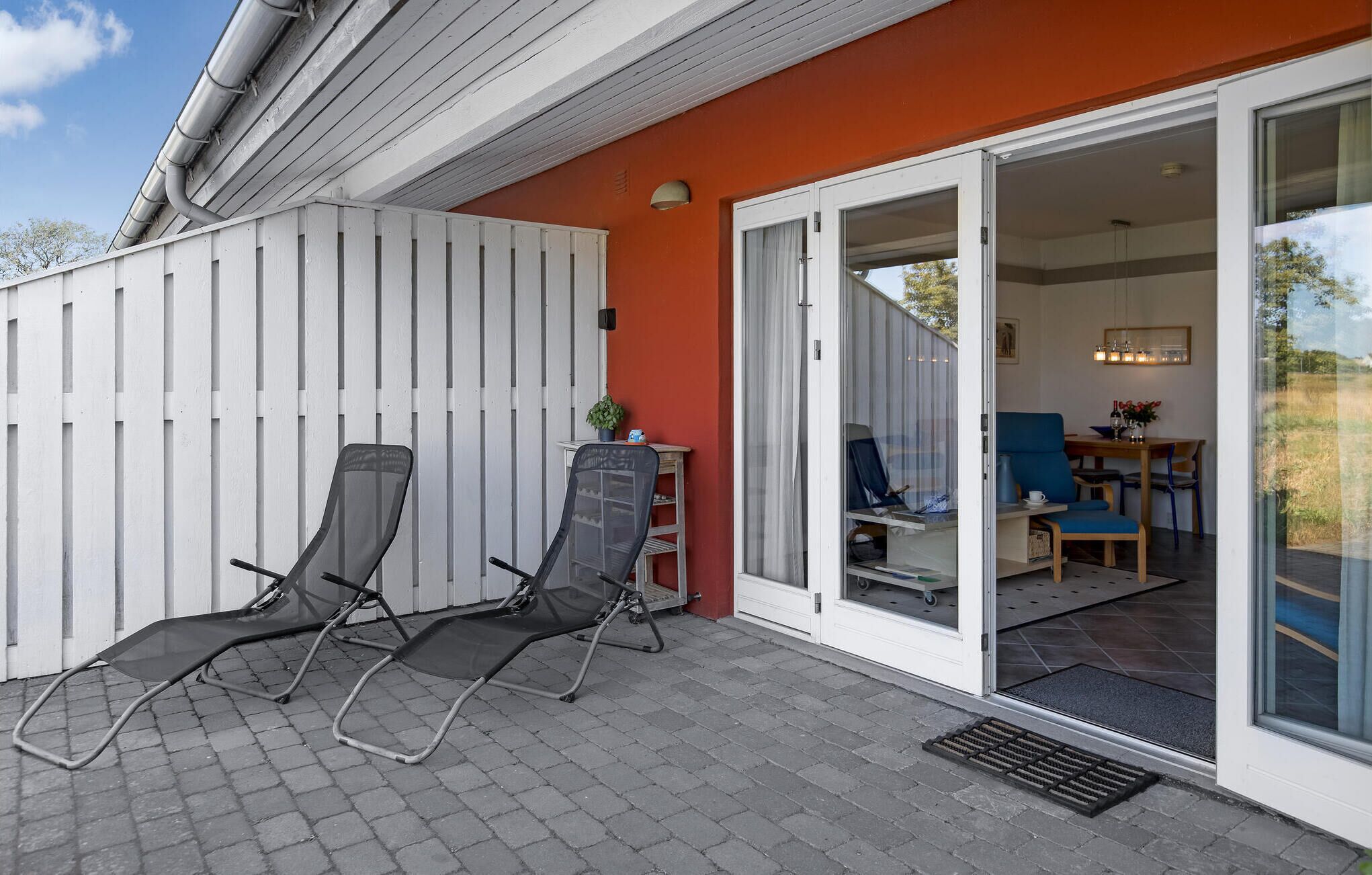 Eine Terrasse mit zwei Stühlen, einem kleinen Tisch und einem Blumentopf.
