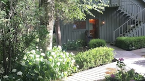 A wooden pathway leading to a building with a staircase and a porch area. - Large beautiful lake front house on Silver Lake MI (Mears)