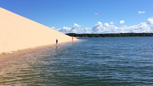 A beach with a sand dune and calm water. - Large beautiful lake front house on Silver Lake MI (Mears)