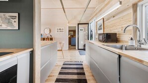 Une cuisine moderne avec des éléments en bois, un four à micro-ondes et un évier.