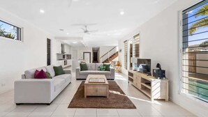 A modern living room with a sofa, a coffee table, and a TV stand.