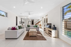 A modern living room with a sofa, a coffee table, and a TV stand.