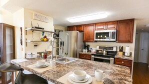 A modern kitchen with granite countertops, stainless steel appliances, and wooden cabinets.