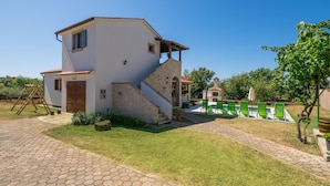 Uma casa de dois andares com uma escadaria de pedra que dá acesso ao andar superior.