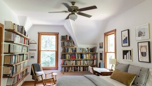 A cozy bedroom with a large bed, a rocking chair, and a bookshelf filled with books. - Cozy Athens Home on the Brook (Athens)