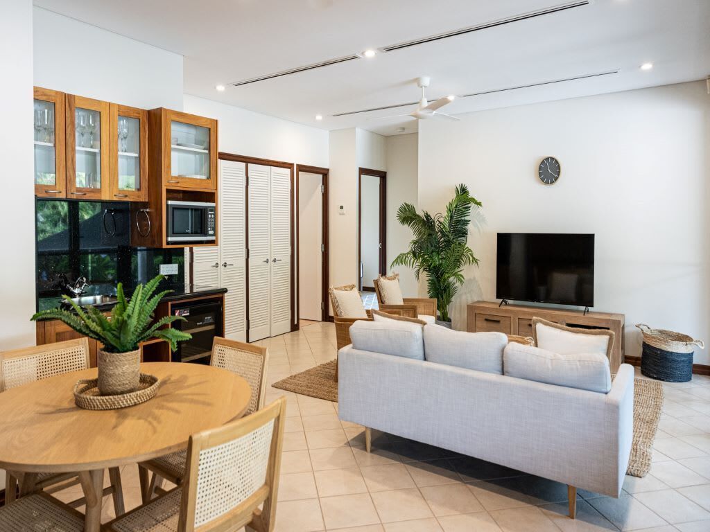 A modern living space with a dining area, kitchen, and seating area.