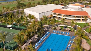 A resort with a swimming pool, tennis courts, and a large building with a curved roof. - Beautiful Golf Course Views - Relax! (Nuevo Vallarta)