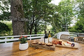 Una mesa de madera al aire libre con un letrero que dice "The Lake", rodeada de árboles.
