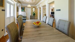 A dining area with a long table, chairs, and a bowl of fruit. - Big Thuja by Interhome (Balatonföldvár)