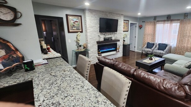 A living room with a fireplace, a television, a sofa, and a dining area with a table and chairs.