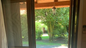 A door with a view of a brick pathway leading to a garden area. - Beautiful and Quiet Villa In Residence In The Po Delta Oasis (Porto Viro)