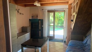 A room with a bed, a table, a cabinet, and a door leading to an outdoor area. - Beautiful and Quiet Villa In Residence In The Po Delta Oasis (Porto Viro)