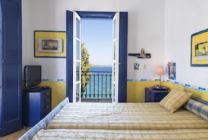 A bedroom with a bed, a TV, a desk, and a view of the sea. - Beachfront Spetses Spectacular Fully Equipped Traditional Villa Families,groups (Spetses)