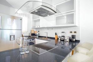 A modern kitchen with a central island, stainless steel appliances, and a sleek design. - Cana Rock Pool View Punta Cana (Punta Cana)