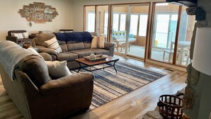 Ein gemütliches Wohnzimmer mit einem braunen Ledersofa, einem Couchtisch und einem Teppich. An der Wand hängt ein Schild mit der Aufschrift "Lake Huron".