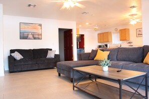 A living room with two sofas, a coffee table, and a ceiling fan. - On River Time!  (Bullhead City)