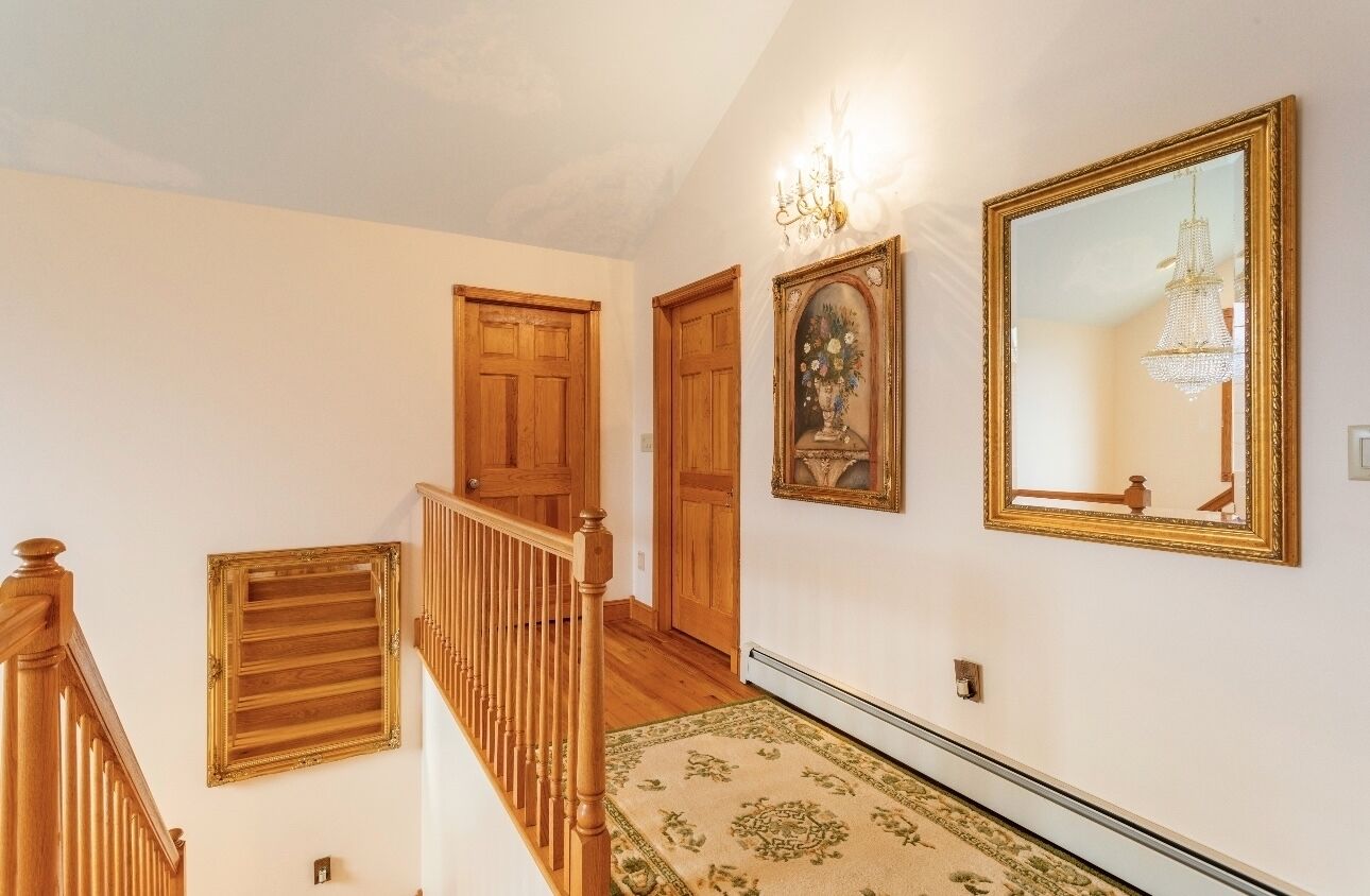 Un escalier avec des rampes en bois et une moquette à motifs.