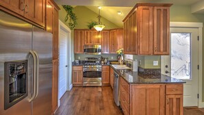 A kitchen with wooden cabinets, stainless steel appliances, and a central island.