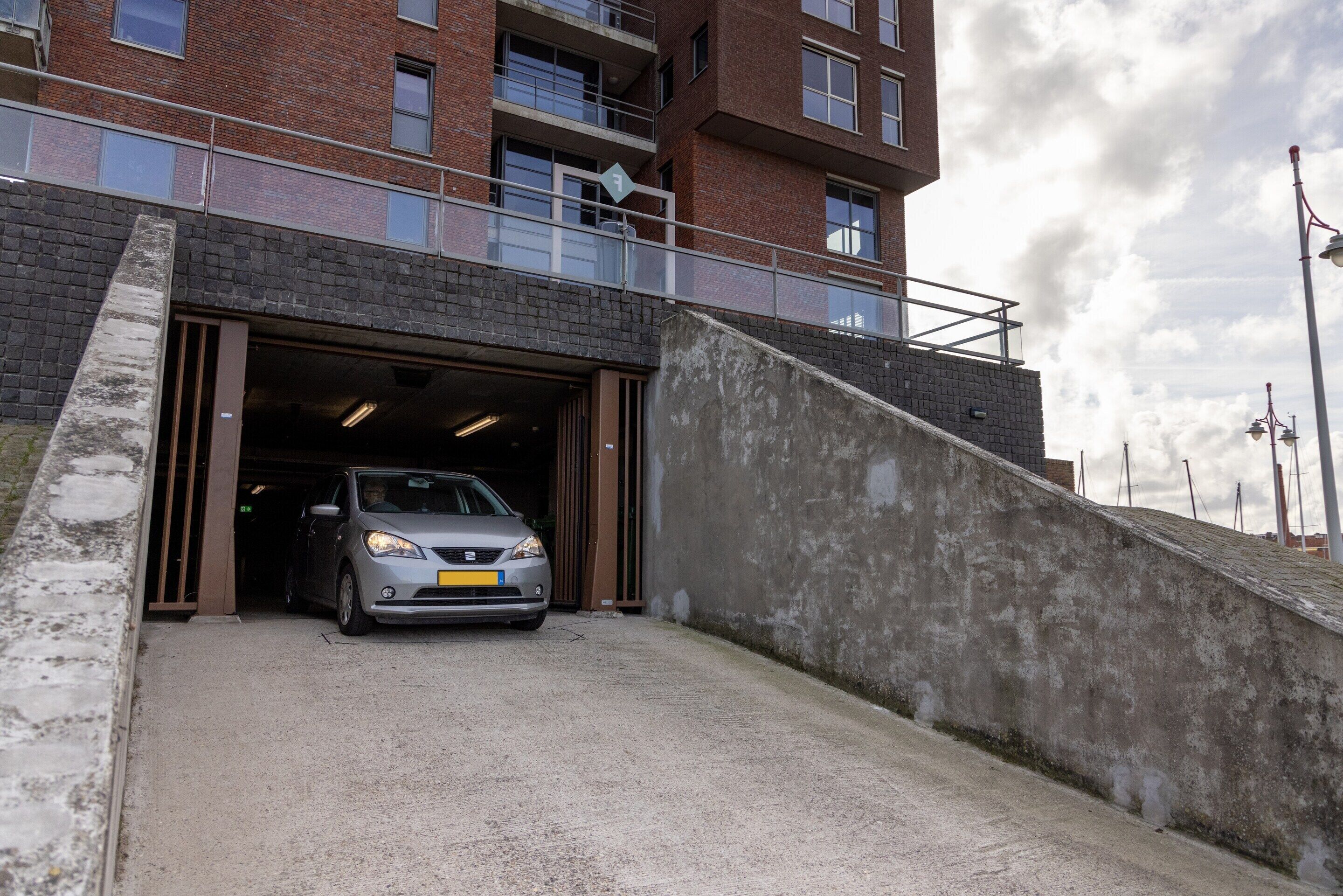 Une voiture qui entre dans un bâtiment par l’entrée du garage.