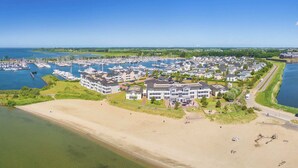 A marina with numerous boats, a beach, and residential buildings. - Villa in Hellevoetsluis Near North Sea Beach (Hellevoetsluis)