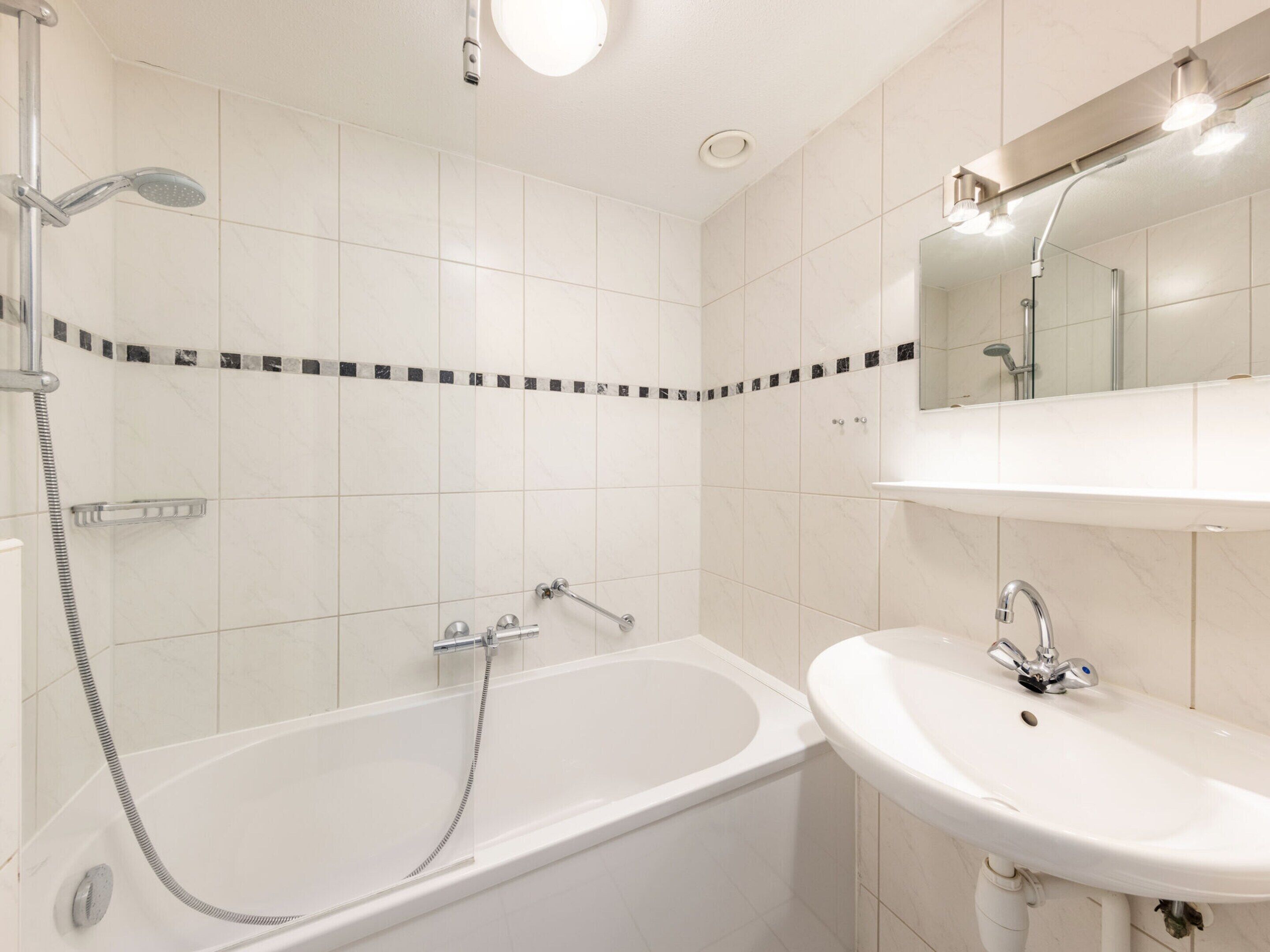 A modern bathroom with a bathtub, a sink, and a shower.