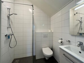 A modern bathroom with a shower, toilet, and sink. - Bungalow in Zeeland Near Sandy Beaches (Domburg)