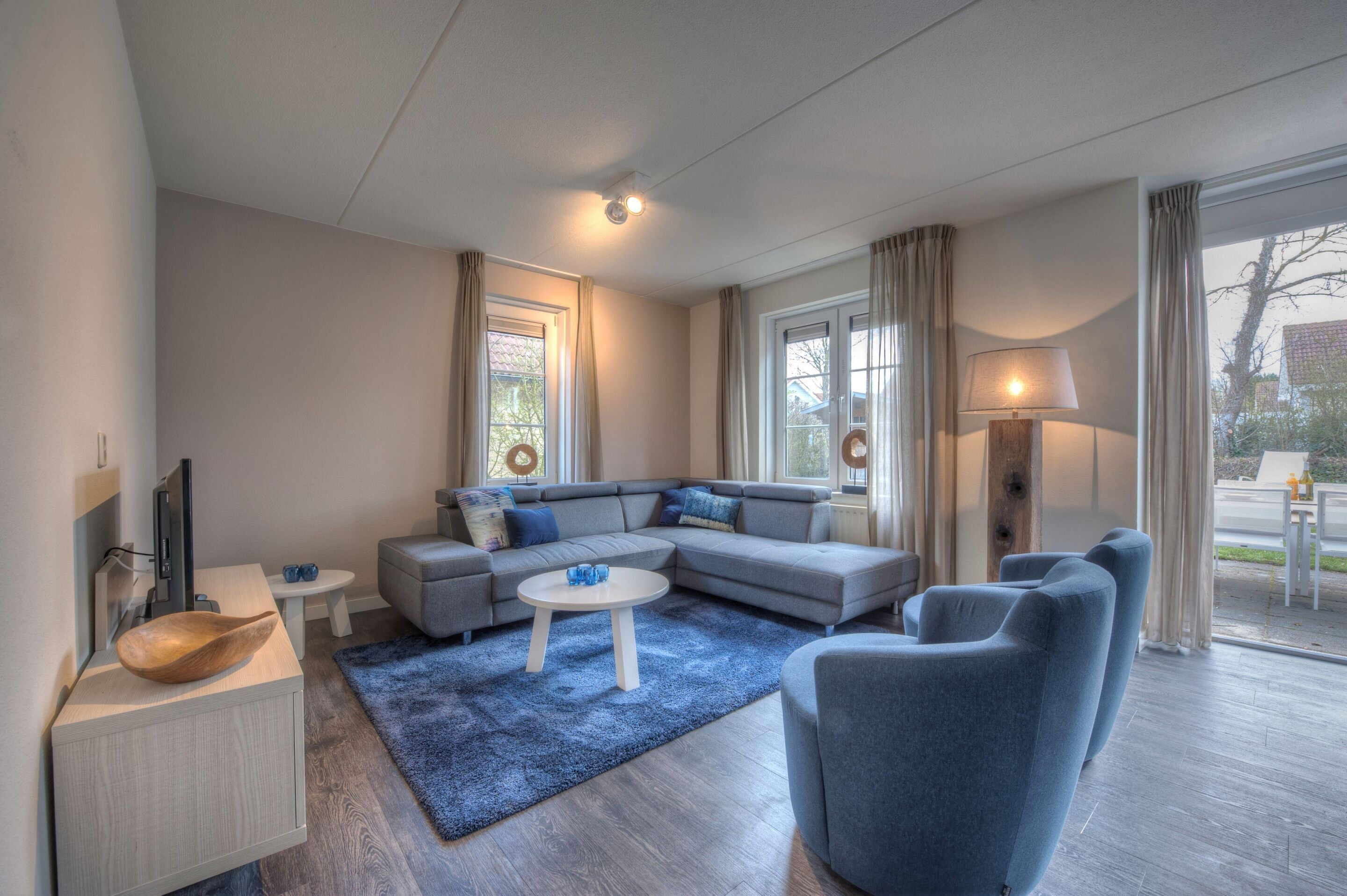 A modern living room with a sectional sofa, a round coffee table, and a flat-screen TV.