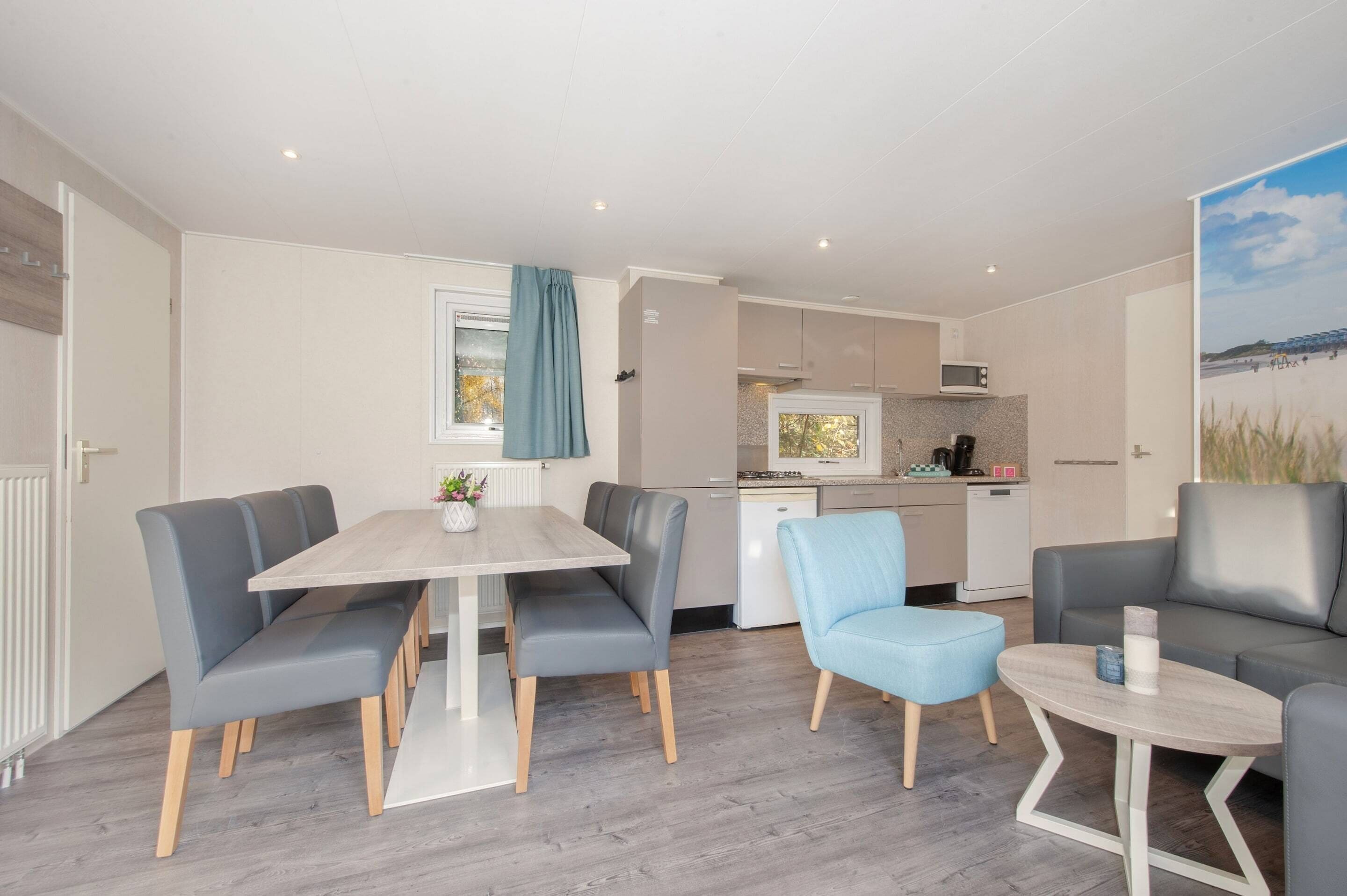 A modern living room with a dining table and chairs, a sofa, and a small coffee table.