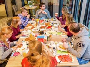 A group of people dining at a restaurant with a variety of dishes and a menu sign. - Bungalow Near Breda & De Biesbosch Park (Oosterhout)