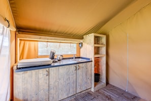 A compact kitchen with a sink, cabinets, and a window.