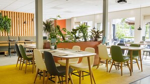 A modern indoor dining area with multiple tables and chairs, wooden accents, and potted plants. - Modern Villa Near Veluwe (Hoenderloo)