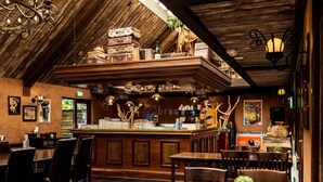 En mysig restaurang med träinredning, en bardel med staplade resväskor och ett varierat utbud av sittplatser.