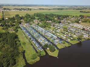 An aerial view of a riverside residential area with houses and mobile homes along the water. - Cozy Chalet With Sloop in Giethoorn (Giethoorn)