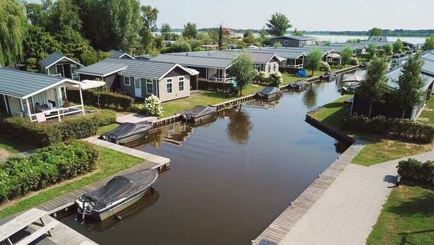 Zona residencial a orillas del río, con casas, muelles y una masa de agua tranquila.