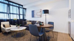 Una sala de estar moderna con un sofá, sillas, una mesa de centro y una lámpara.