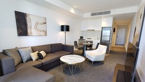 Una sala moderna con un sofá, una mesita redonda y un comedor con una silla.