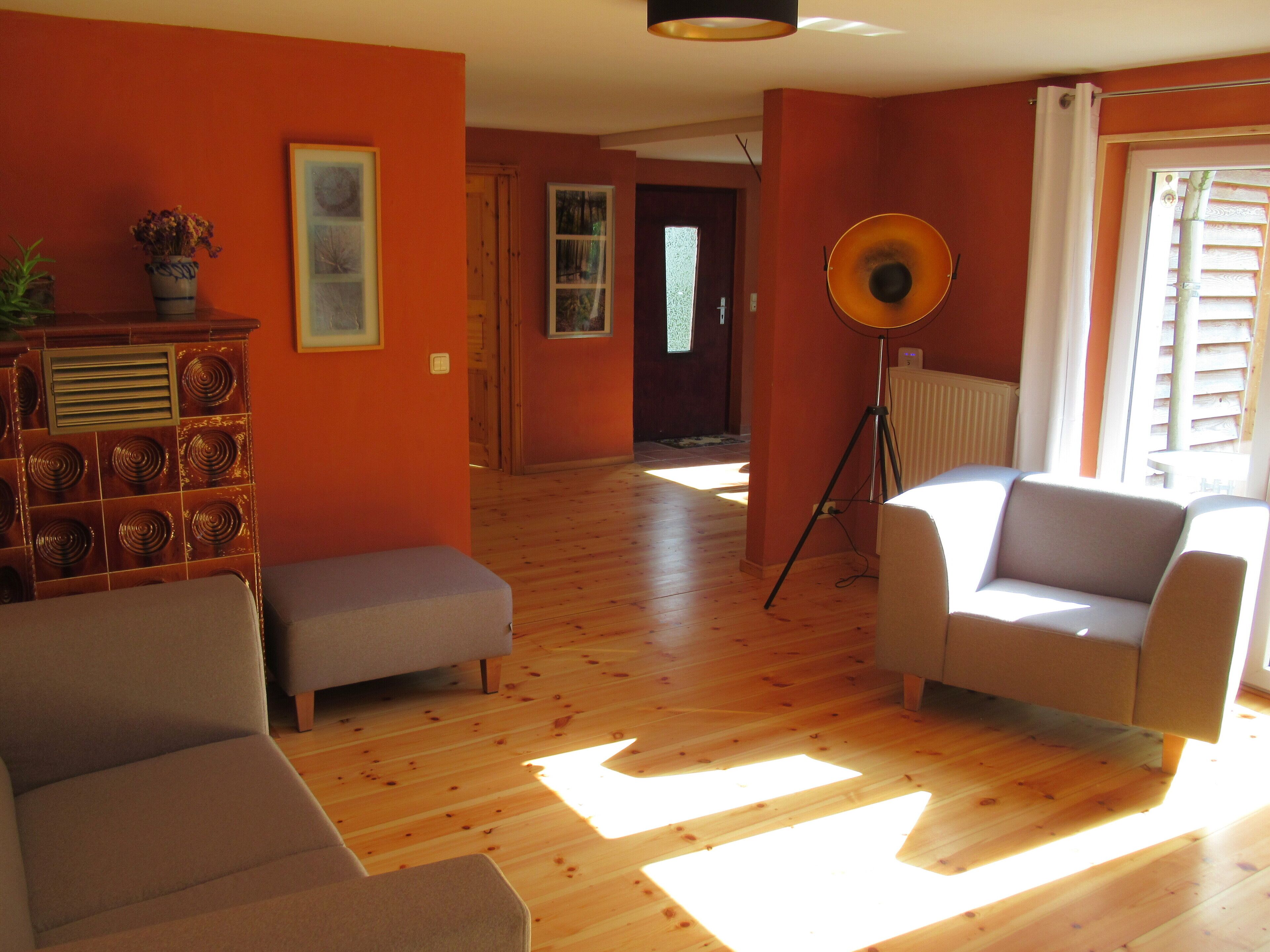 Un salon avec deux canapés, une lampe sur pied et un radiateur.