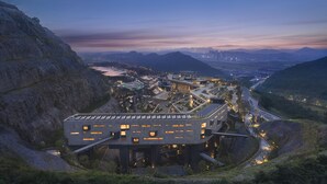 Um edifício moderno com vários andares, grandes janelas e um design complexo com seções interligadas.