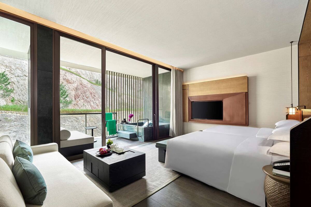 Een moderne hotelkamer met een groot bed, een bank, een salontafel en een televisie.