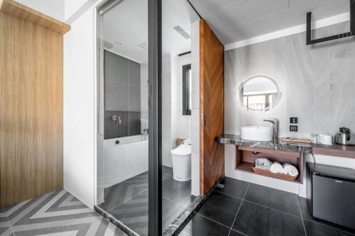 Une salle de bain moderne avec une douche à parois de verre, des toilettes, un lavabo avec un miroir et un meuble encastré.