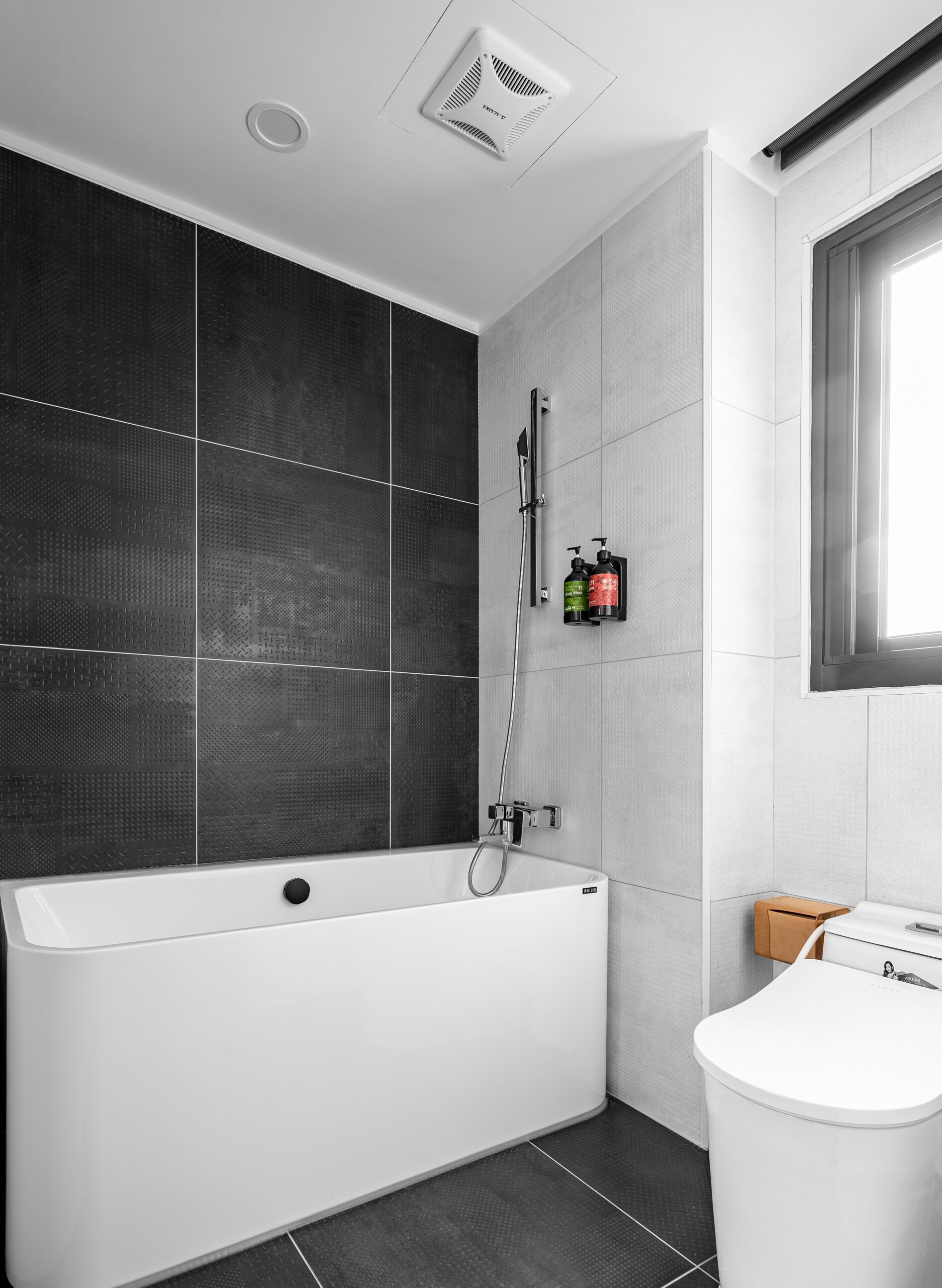 A modern bathroom with a freestanding bathtub, a showerhead, and a toilet.