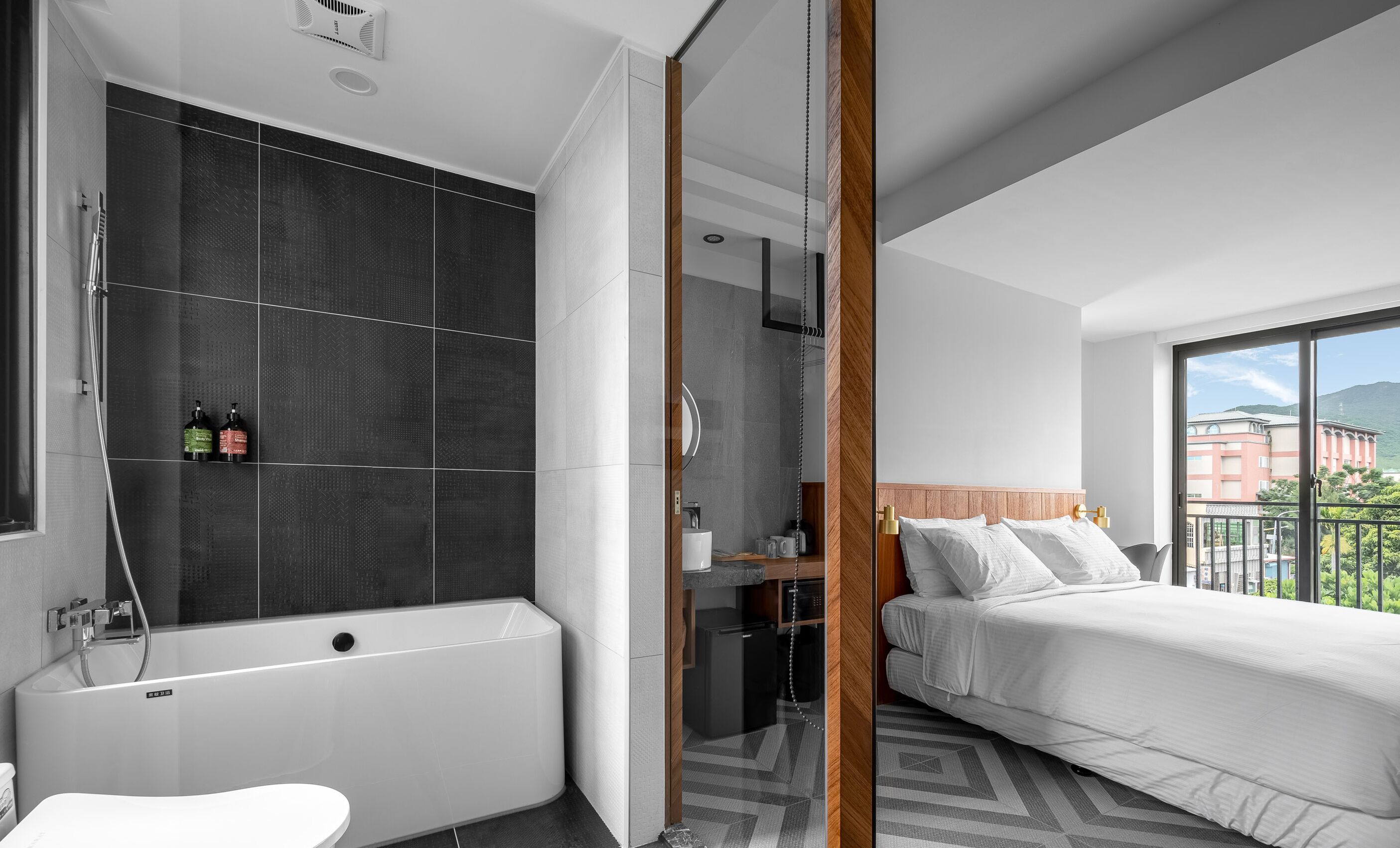Habitación de hotel moderna con bañera, cama y vistas a la ciudad.